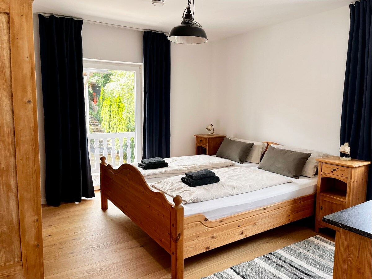 Schlafzimmer mit Holzbett und Balkonzugang