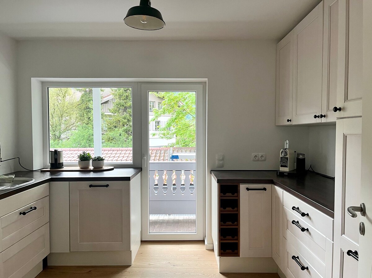 Küche mit weißen Fronten und dunkler Arbeitsplatte